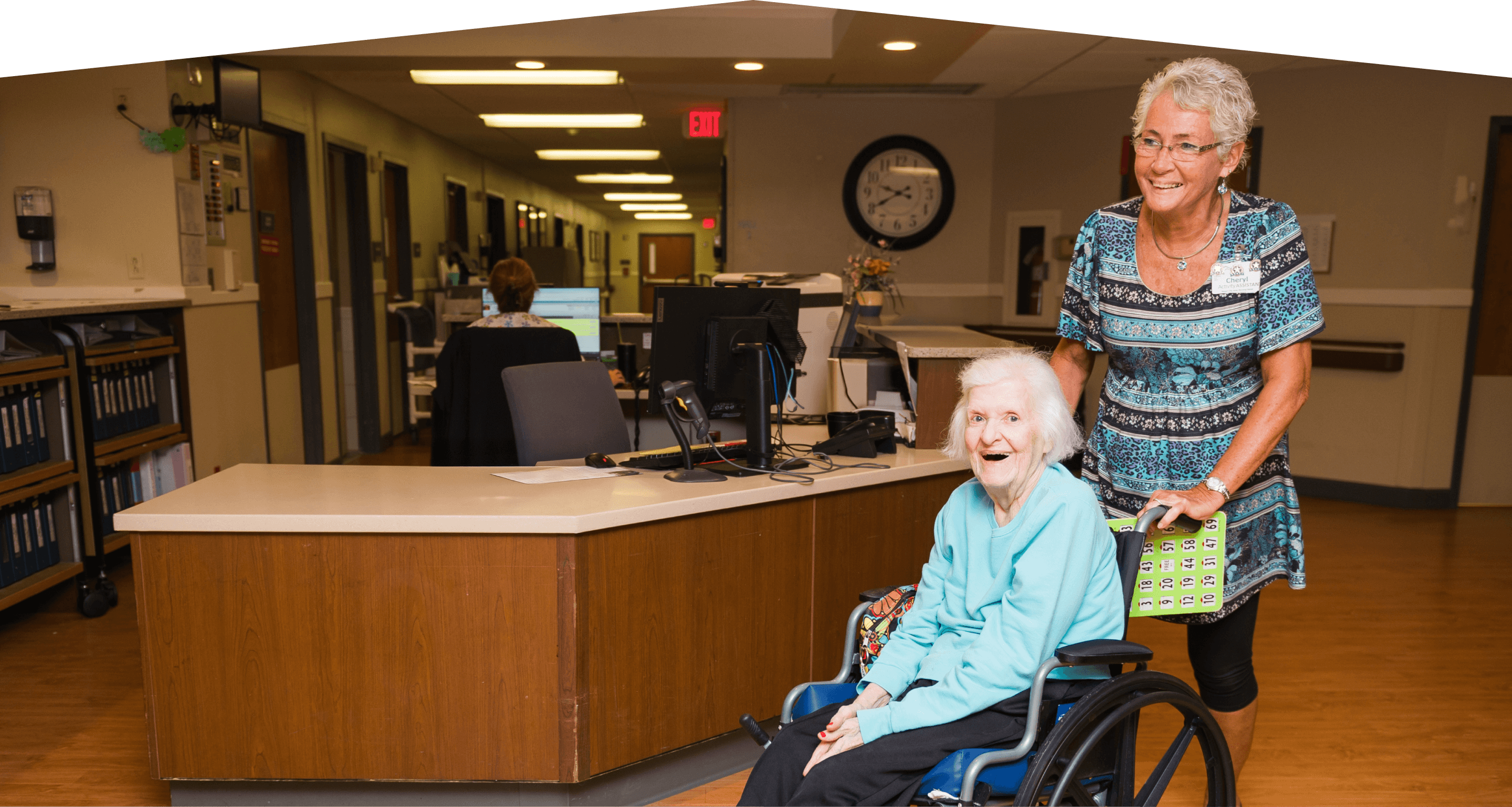 Resident in wheel chair pushed by woman.